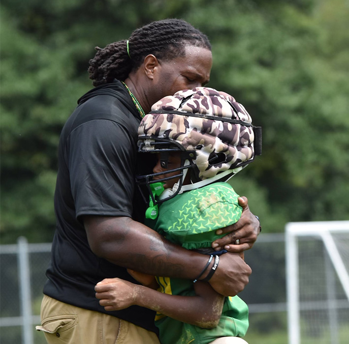 Featured: Coach Kiven addressing his 25 youth football players (left), HC Trae Addison (right)